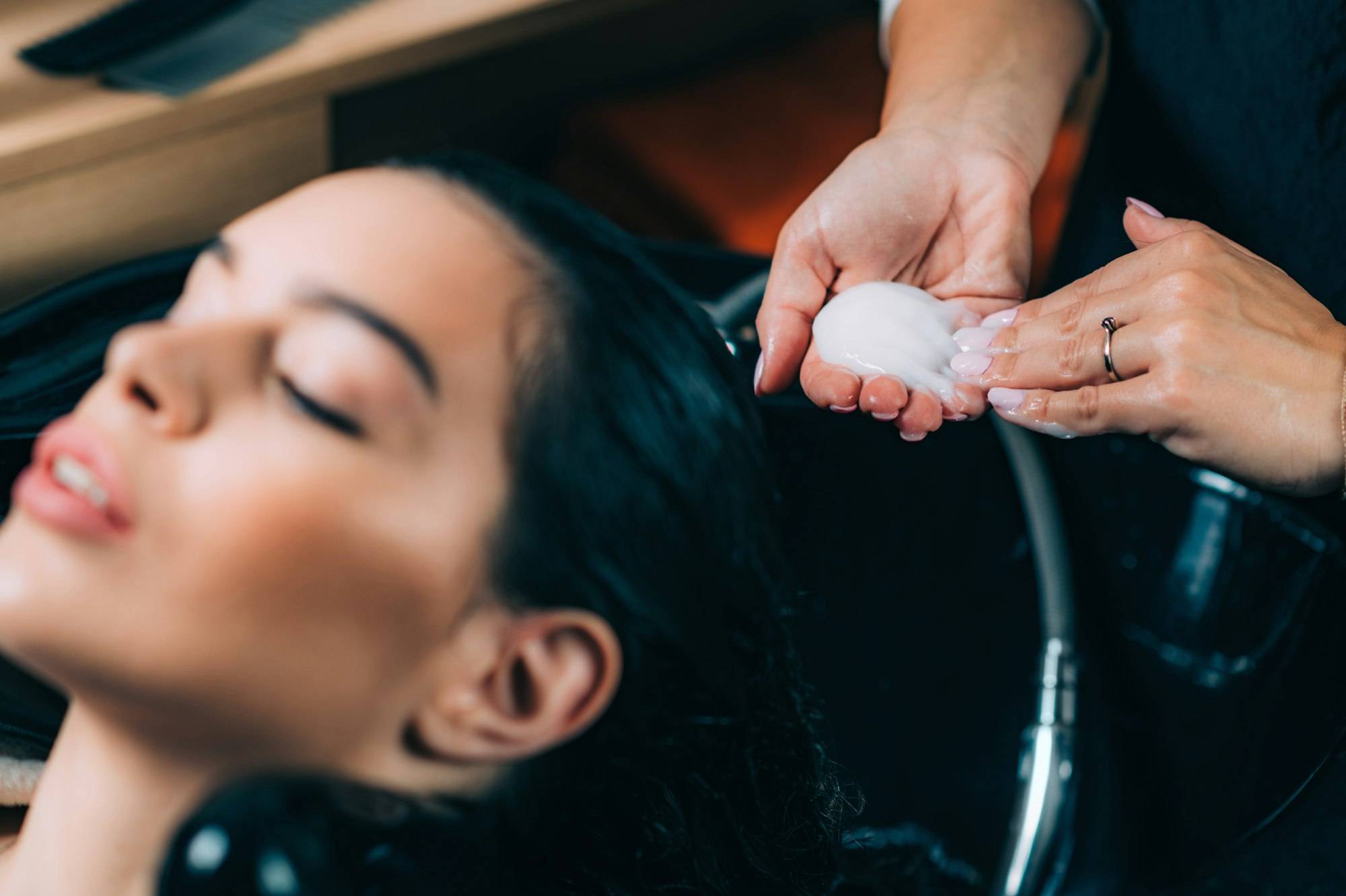 Hairdresser’s Hands Applying Conditioner