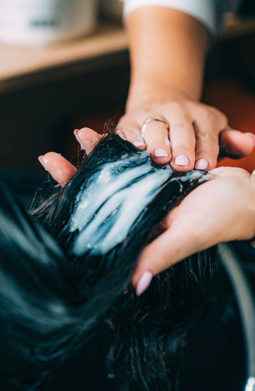 Hairdresser’s Hands Applying Conditioner